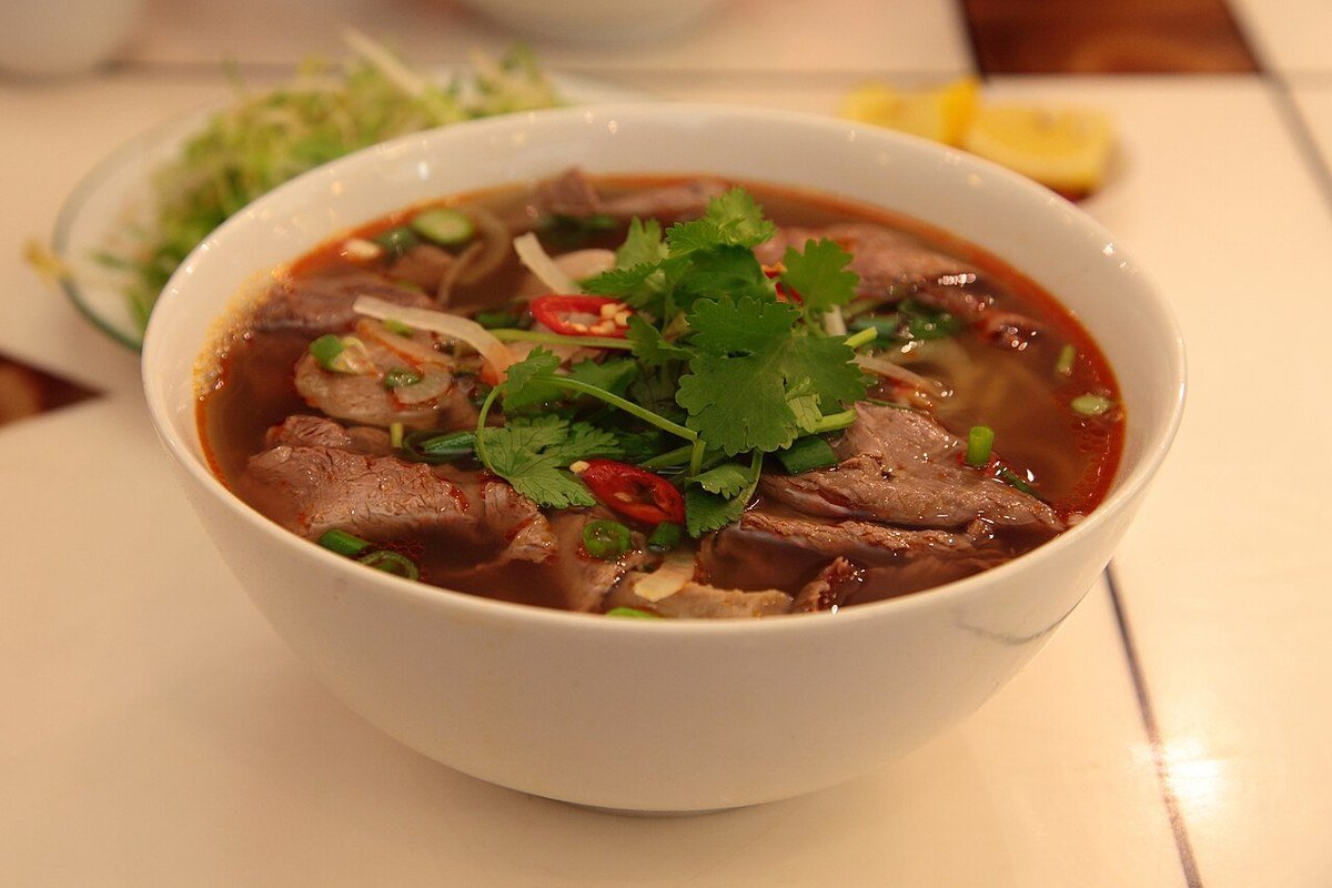 Tô bún bò Huế bắp giò chả cua đầy đặn nước dùng trong veo màu cam đỏ tại quán Bà Mô 200 Lê Thánh Tông Buôn Ma Thuột
