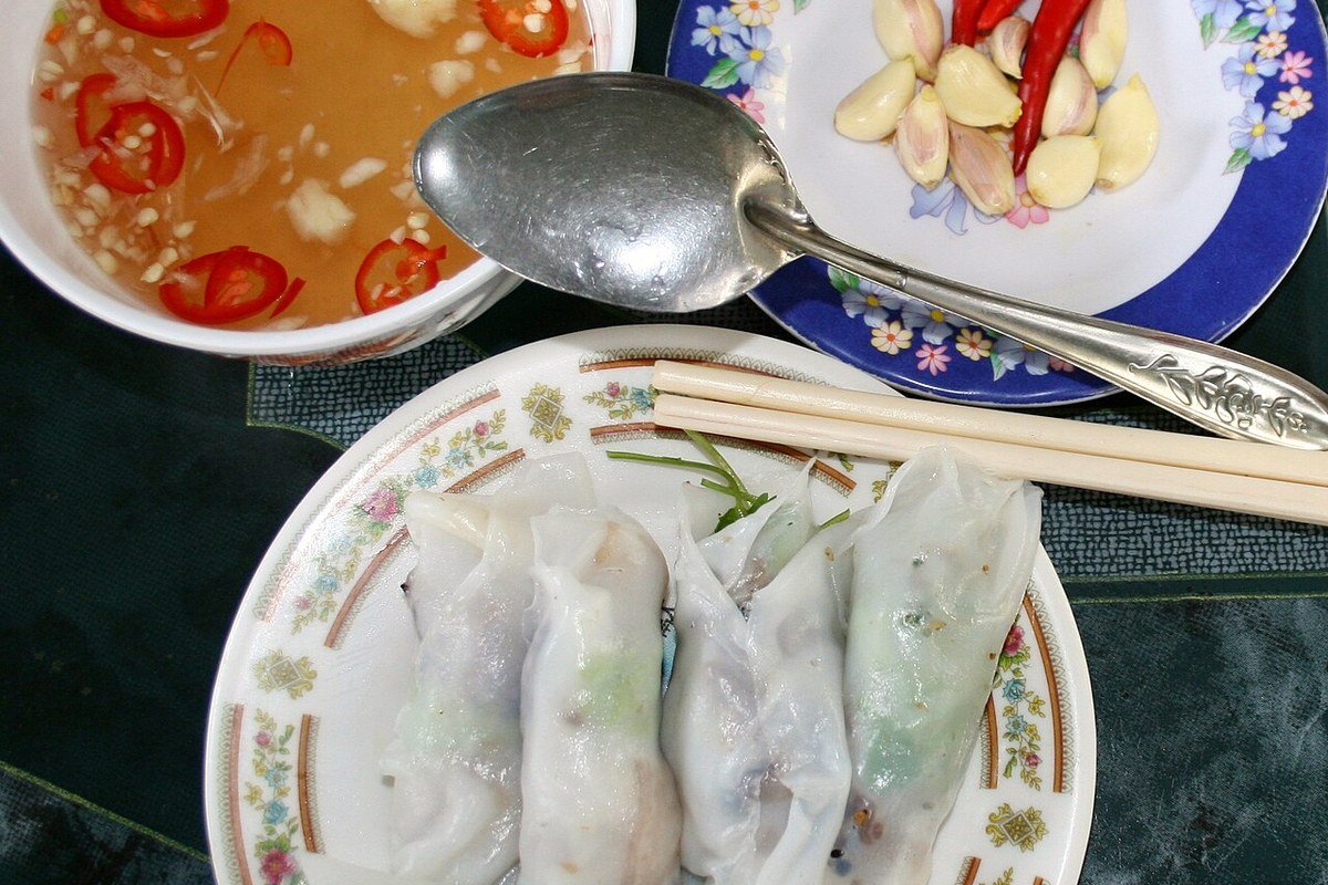 Đĩa bánh cuốn nóng bốc khói nghi ngút ăn kèm chả lụa chả quế tại chợ đêm ẩm thực Buôn Hồ Đắk Lắk